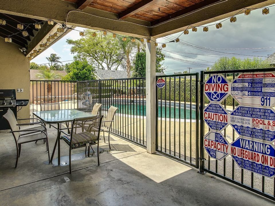 - Covered patio with dining table and poolside view   - String lights add cozy charm for evening gatherings   - Perfect outdoor setup for meals and relaxation