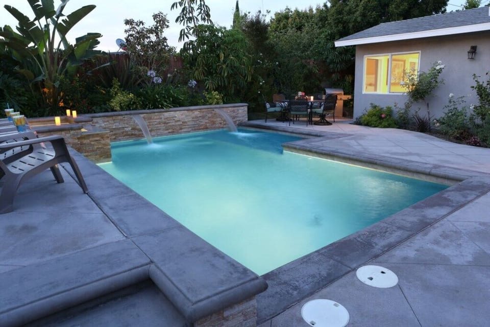 Stunning Pool and Jacuzzi with Waterfall Feature at dusk