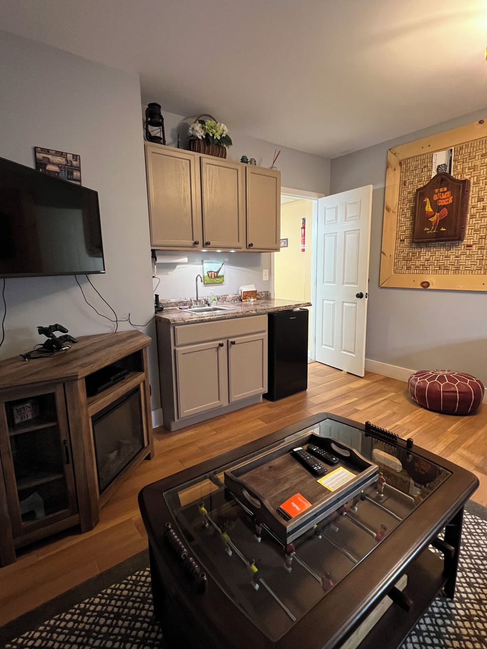 lounge/game room, tv, wet bar mini fridge, card table, foosball coffee table   