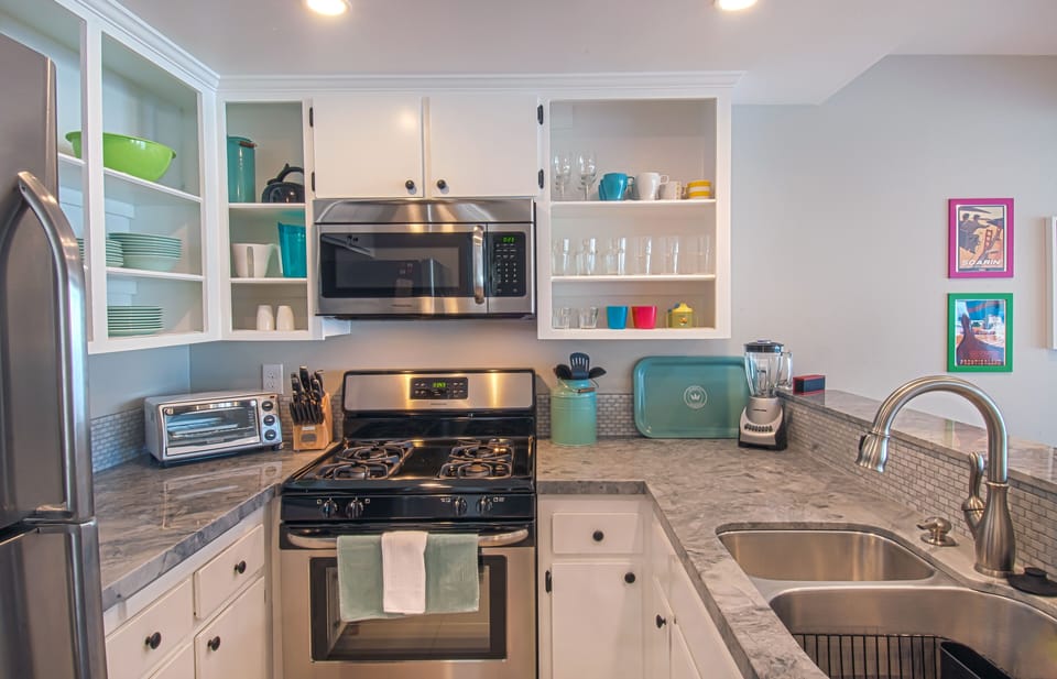 - Fully equipped kitchen with stainless steel stove oven and microwave ready   - Open shelving stocked with colorful dishware and essentials for easy use   - Airbnb optimized caption using modern kitchen and cooking space keywords