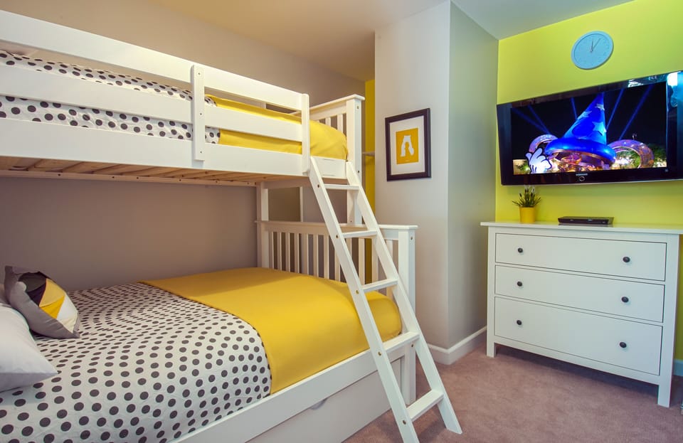 - Bunk bed room with TV dresser and cozy bright bedding for family stays   - Vibrant yellow decor creates a fun playful vibe kids will absolutely love   - Airbnb optimized caption using bunk bed family room and kid friendly stay