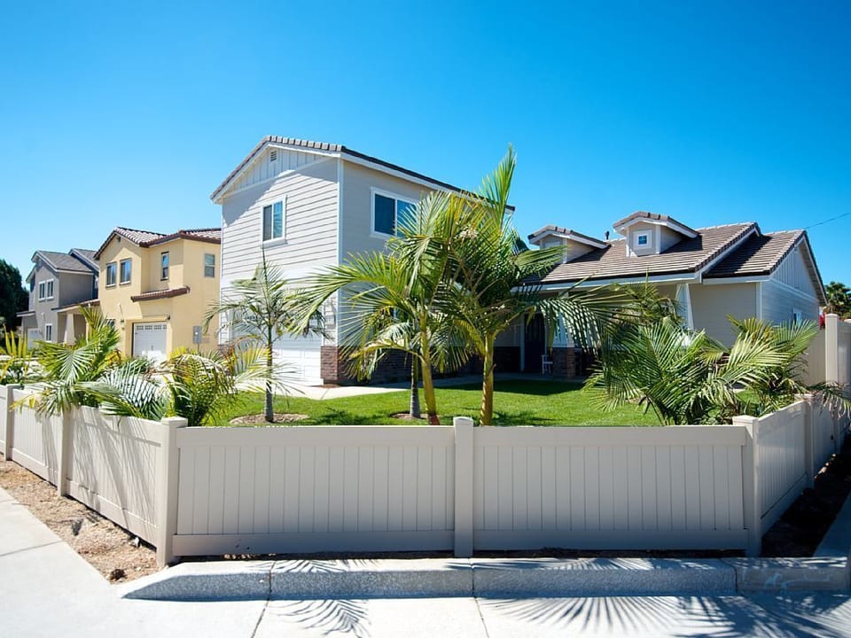 - Tropical-inspired home exterior with palm trees and sunny curb appeal   - Spacious fenced yard provides privacy for families and group stays   - Beautiful vacation home with easy access to nearby attractions