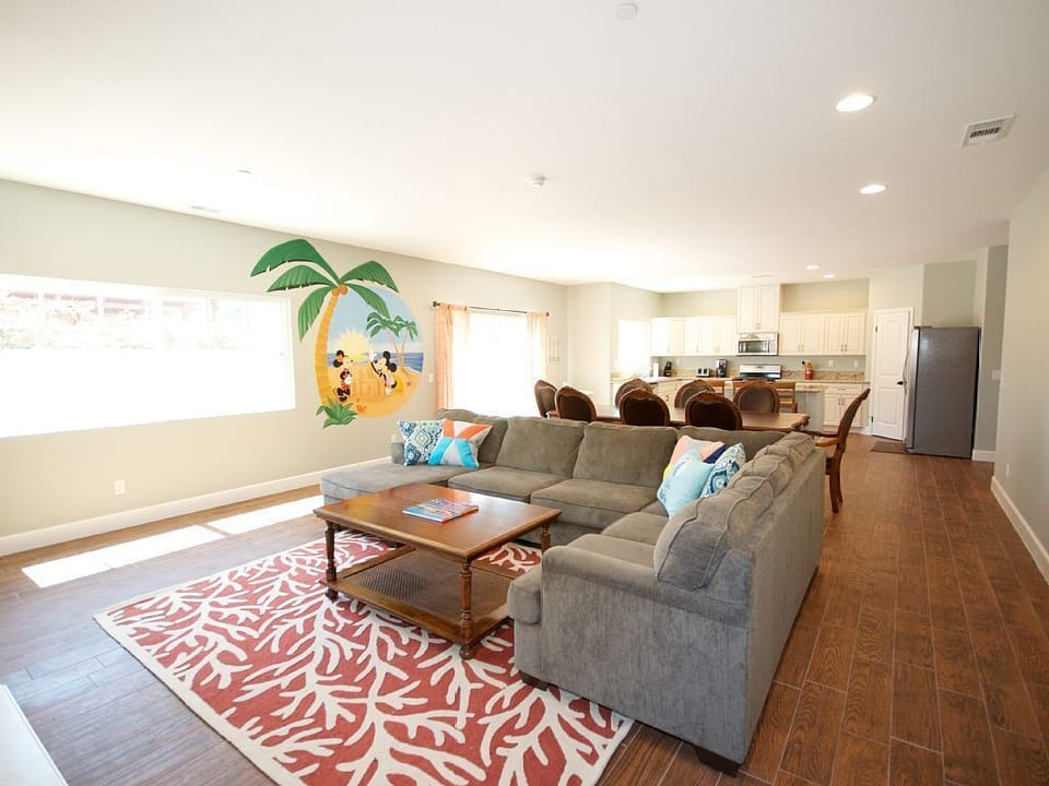 - Bright open living room with sectional sofa and family-friendly design   - Cheerful wall mural adds playful charm for kids and groups to enjoy   - Comfortable lounge space connected to dining and kitchen for gatherings