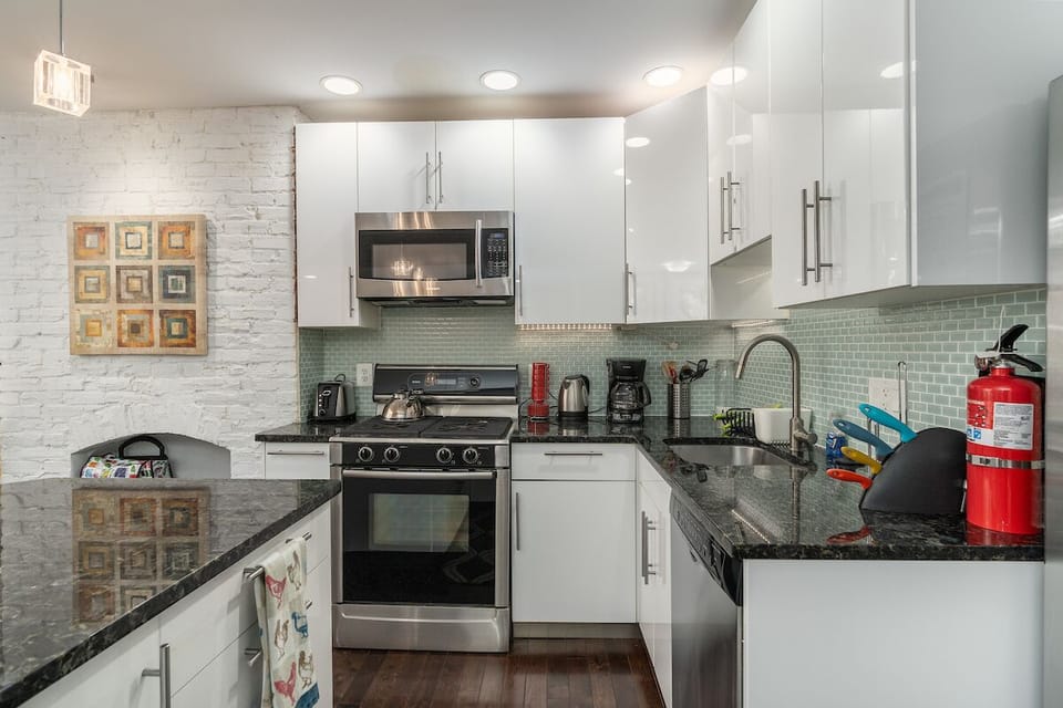 kitchen with stove, sink, oven, microwave, fire extinguisher.
