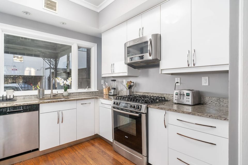 kitchen with view of dishwasher, stove/oven, sink, microwave, toaster