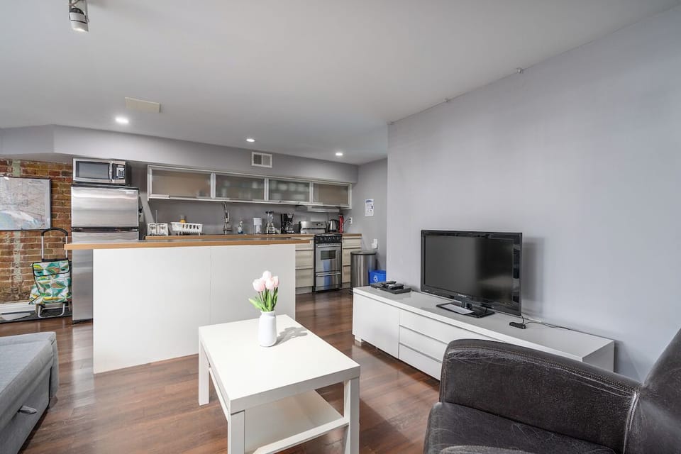 living room with coffee table, tv, and arm chair