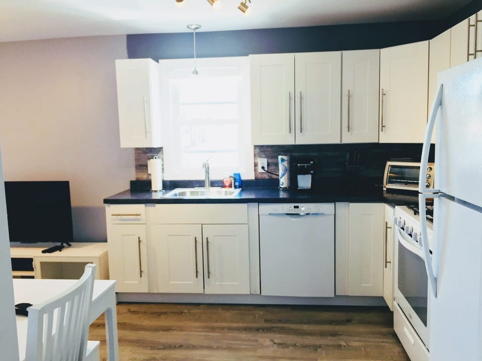 kitchen area w/ dishwasher, oven/stove, fridge & Keurig