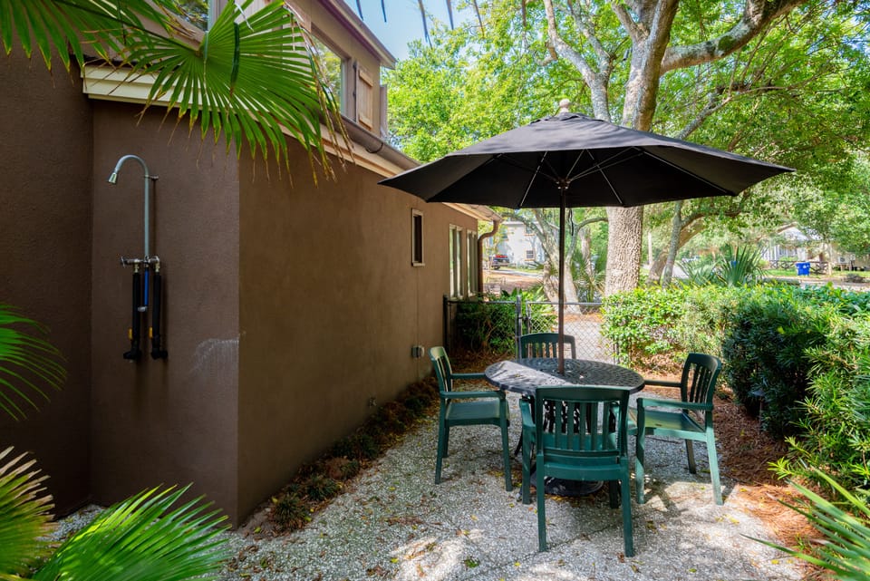 Private outdoor area, completely fenced in yard with lush landscaping, concrete patio seating area and outdoor shower for a rinse off after the beach!
