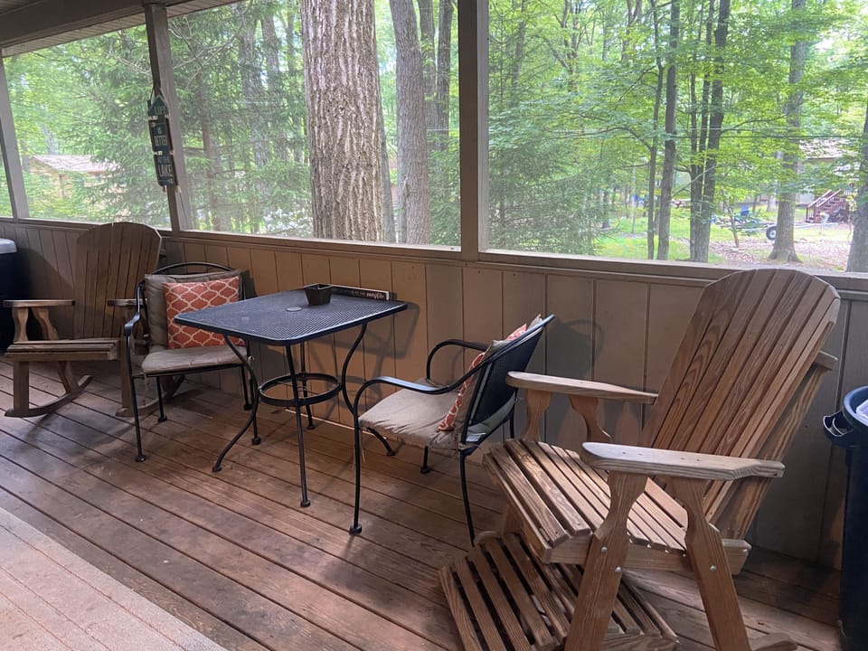 Screened in back porch with table and chairs, hot tub