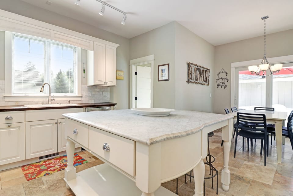 Honed carrara marble countertops enhance the beautiful kitchen design.