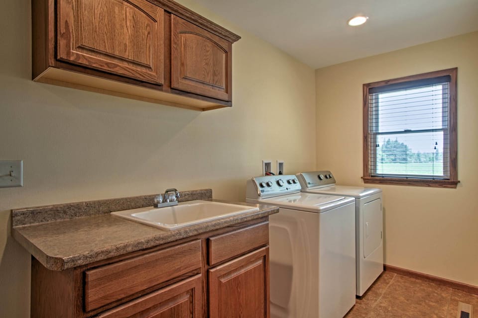 Large utility room with full size washer, dryer, and utility sink.