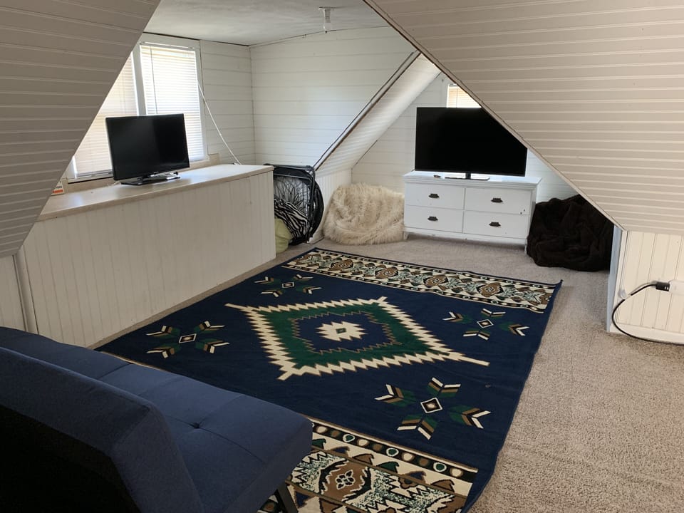 3rd floor TV area with futon and 4 twin beds