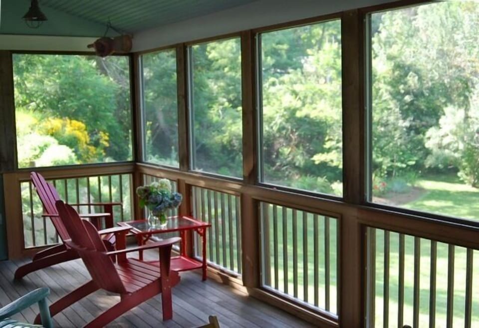 Screened in back porch overlooks landscaped backyard