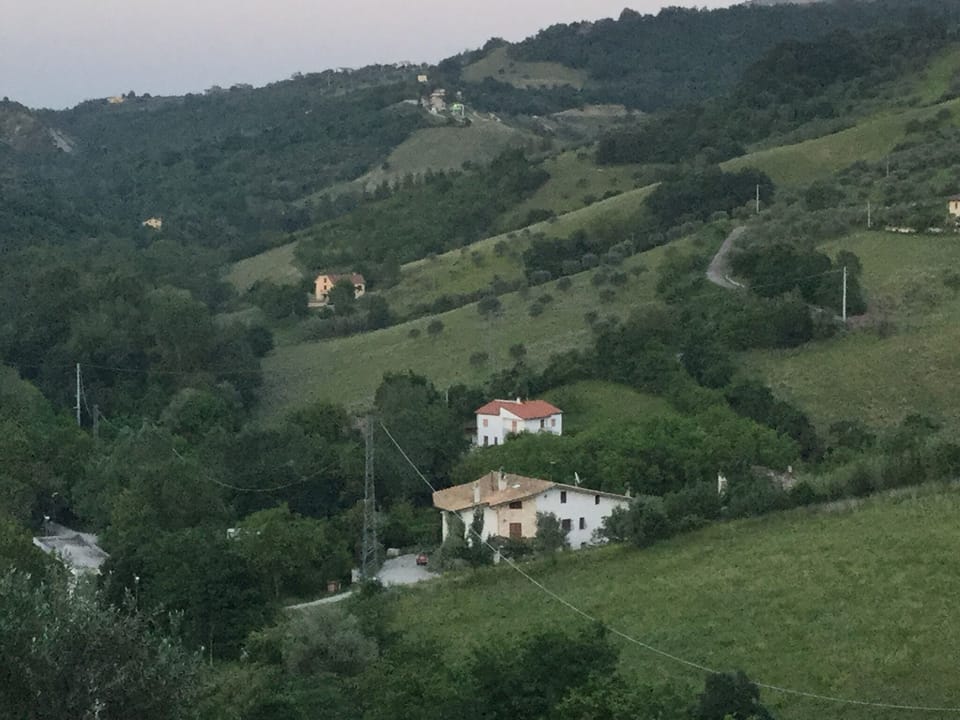 house seen as white speck on top of hill
