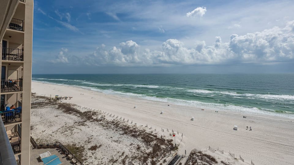 Gaze at the expansive shoreline and rolling waves, creating a serene backdrop for your beach getaway