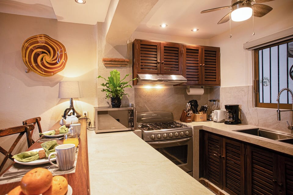 REMODELED KITCHEN WITH NEW COUNTERS, BAR, SINK AND LIGHTING 