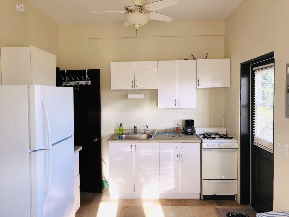 small kitchen with gas stove, full size fridge, toaster, coffee maker blender