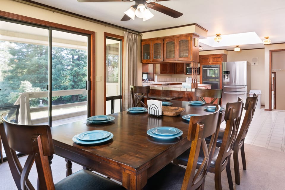 Dining room has large glass windows and a sliding door going out to the balcony.