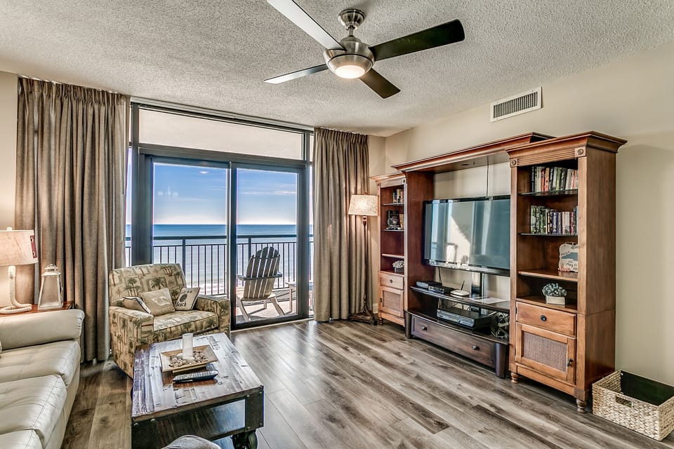 Living room with balcony access and large flat-screen TV