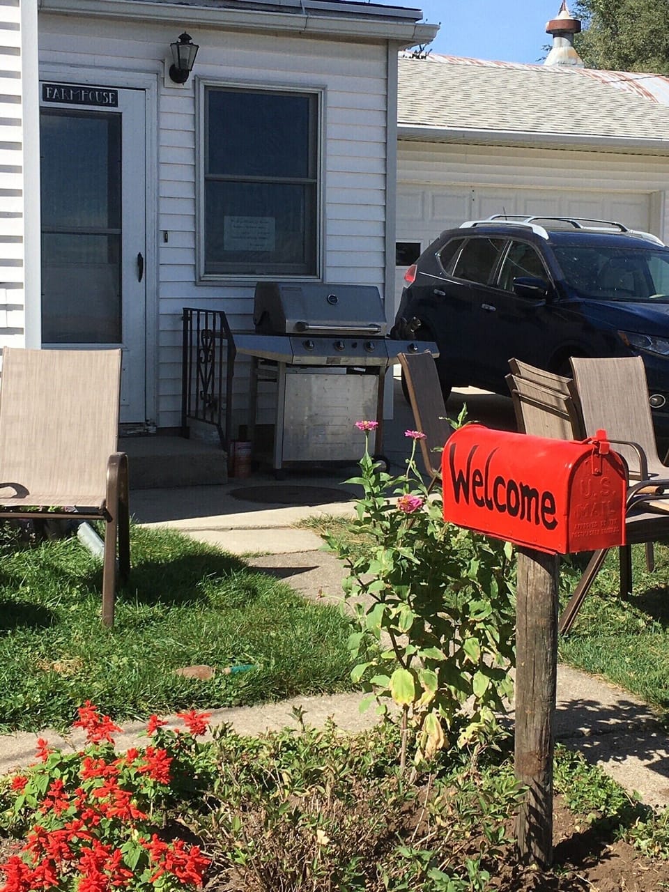The red mailbox welcomes guests and provides direction to entry, by the grill.