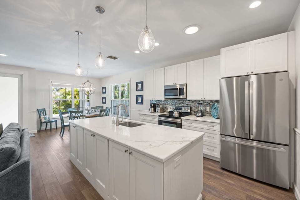 Spacious kitchen island with pristine white cabinetry and quartz countertops
