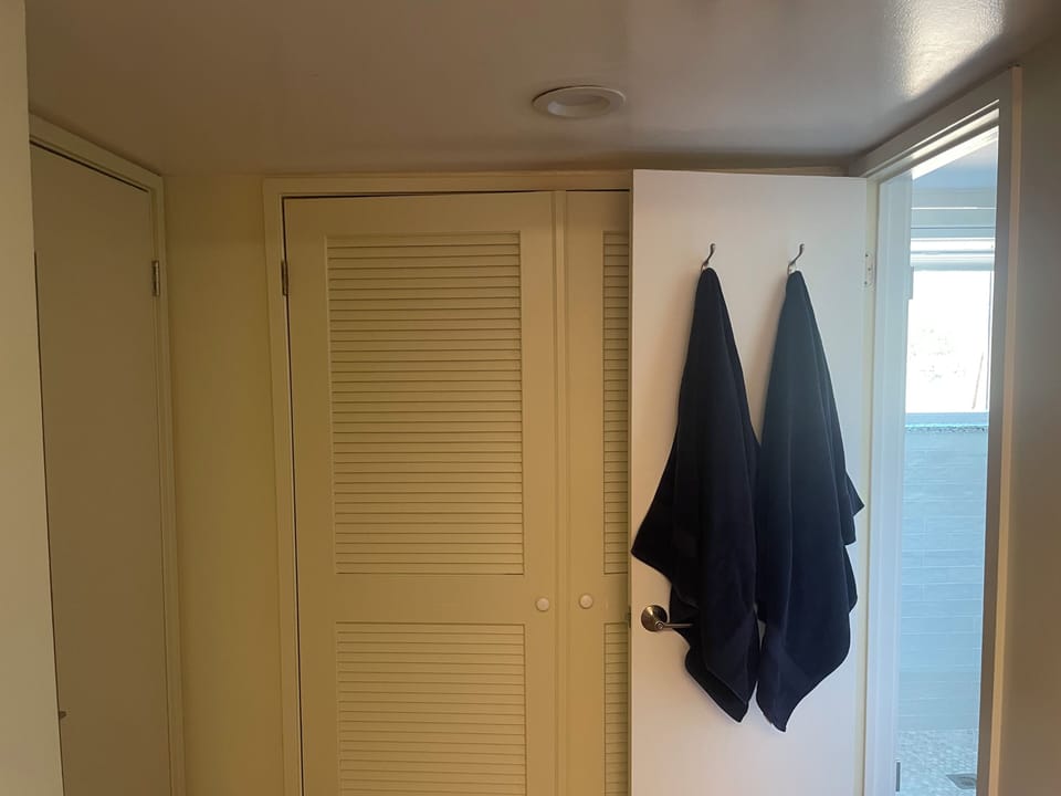 Doors to W/D to the left of back bathroom (bathroom door opens into area)