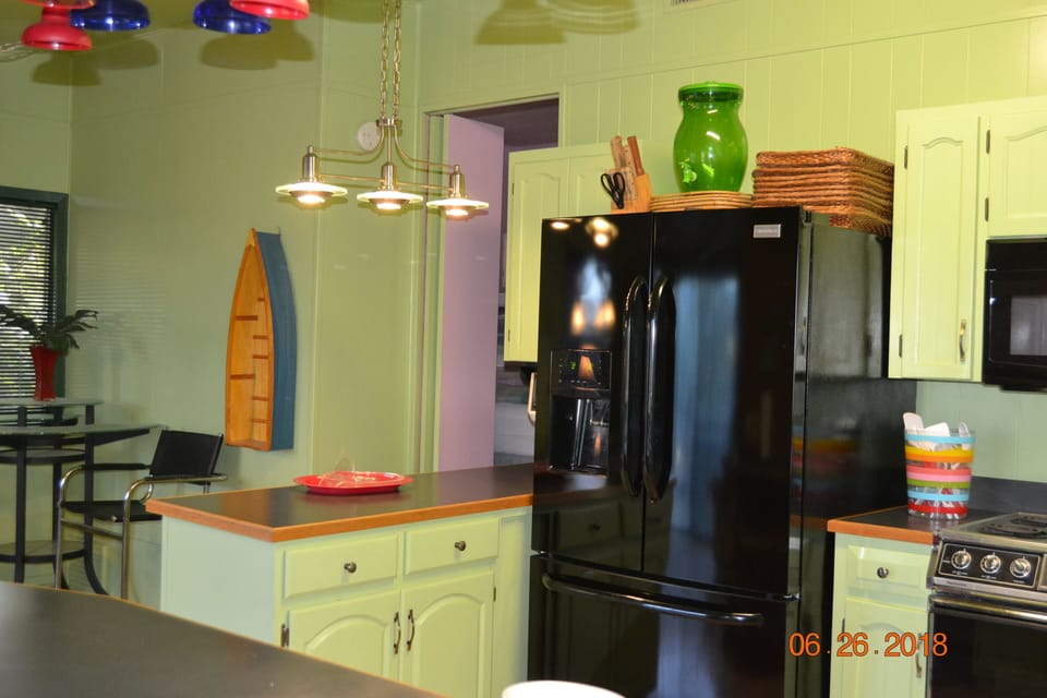 Three door frig and entrance to pink bedroom.  Complete kitchen in this space.