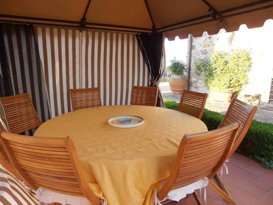 Round table for 8 in West patio - curtains drawn closed on 2 sides