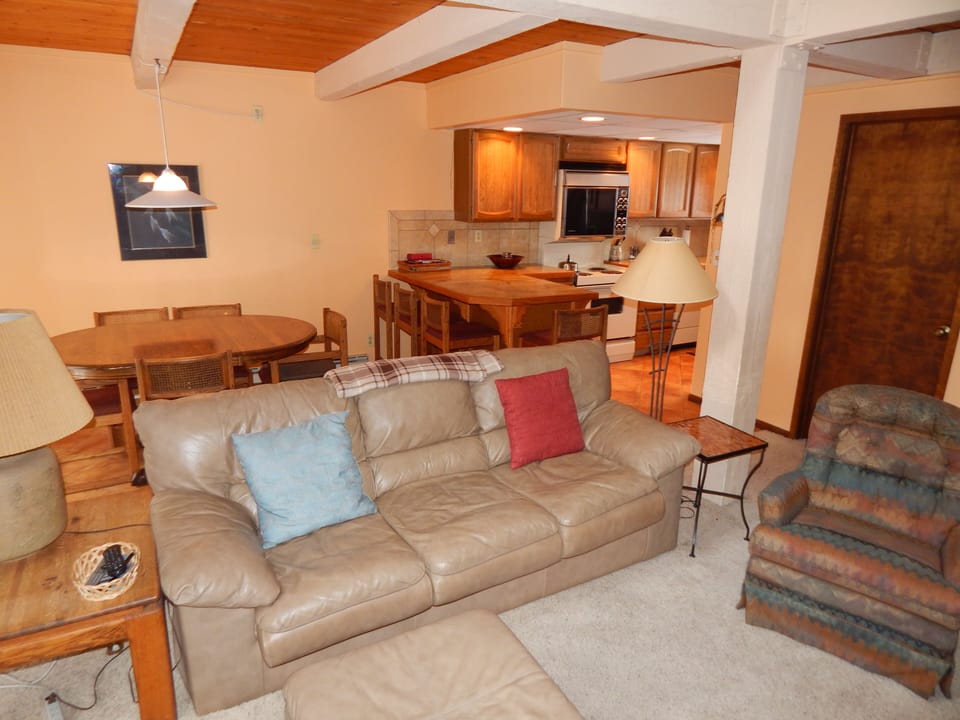 Relax in this cozy open-concept space where your comfortable leather sofa flows seamlessly into a fully-equipped kitchen, perfect for memorable meals together.