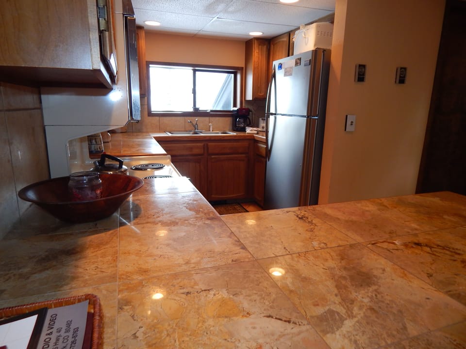 You'll love preparing meals in this spacious kitchen with granite countertops, modern appliances, and warm wood cabinetry creating your perfect culinary retreat.