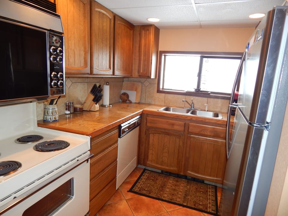 Your fully equipped kitchen features warm wood cabinets, modern appliances, and everything you need to create memorable meals during your stay.