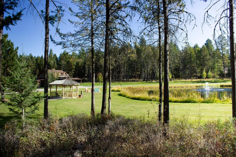 Step outside to emerald lawns sweeping down to your own glassy pond, framed by towering pines and mountain sky.