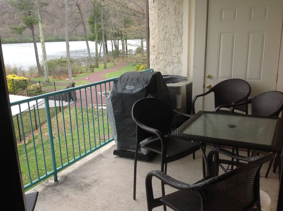 balcony overlooking lake with gas barbeque and outdoor patio furniture