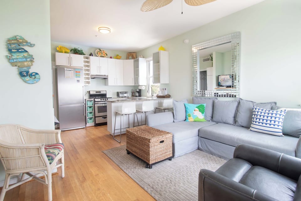 Relax in your open-plan living area where coastal breezes and beachy décor set the tone for your getaway. Sink into the comfy sectional after a day exploring nearby shores.