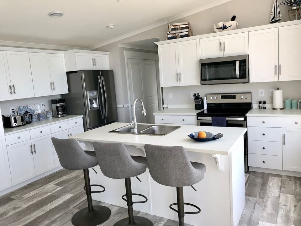 Modern entertainment kitchen with island, barstools and 5 appliances