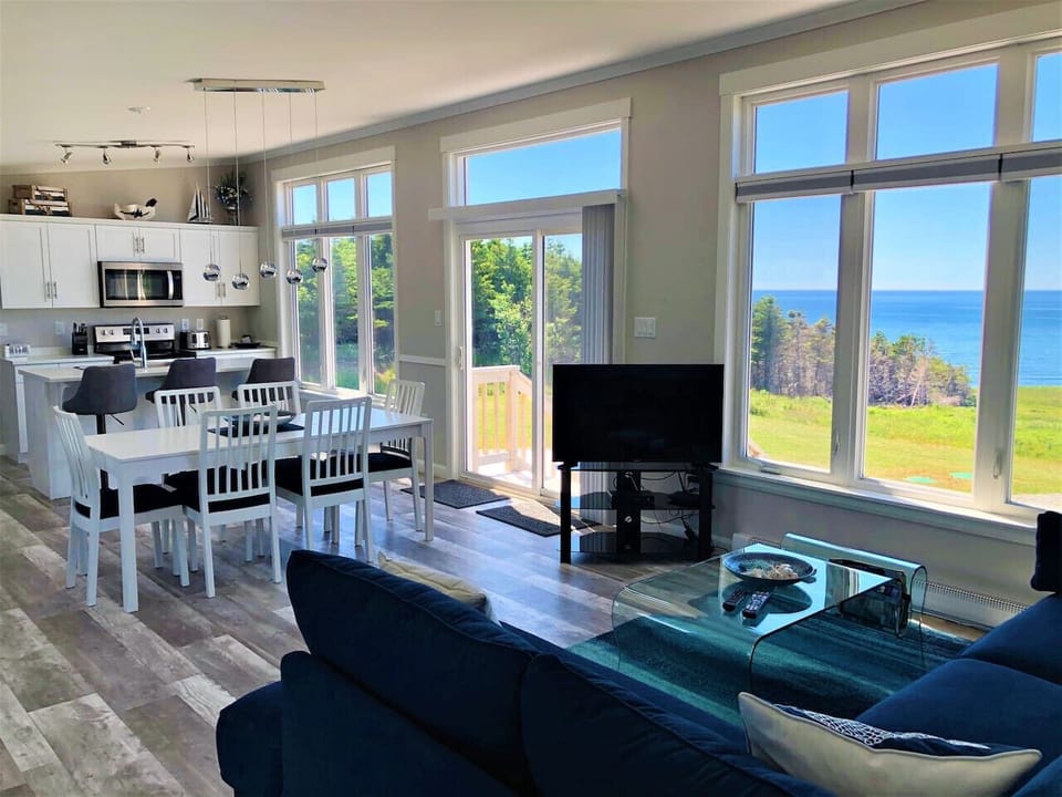 Open concept living and dining area with high ceilings and ocean views