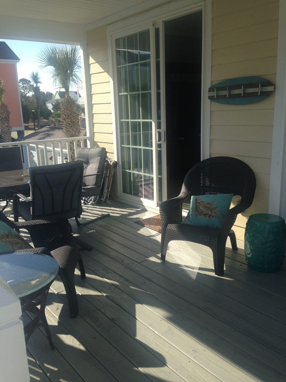 covered porch with dining area and sitting area. Place to hand beach towels.