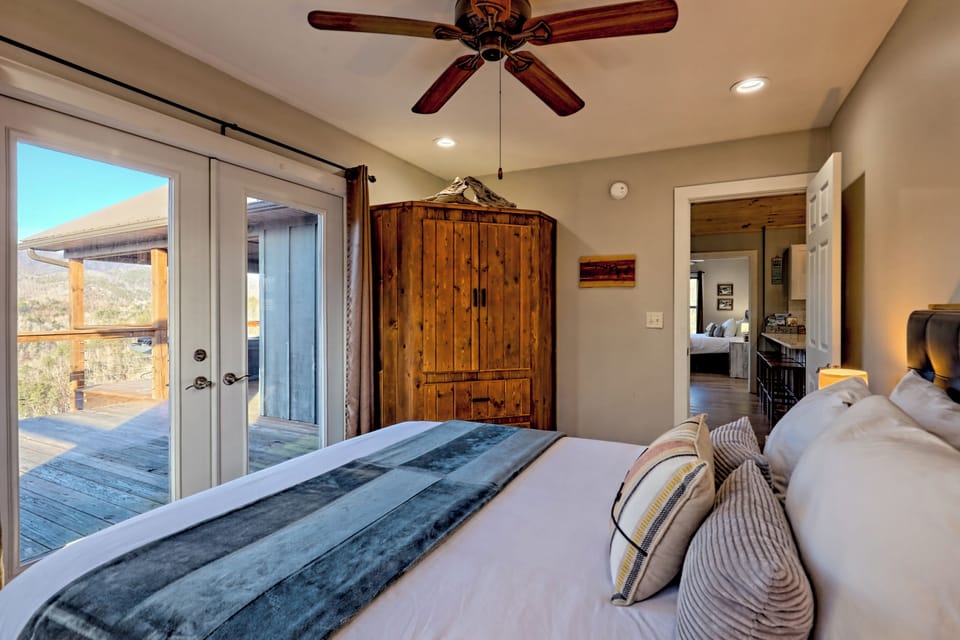 Cozy rustic bedroom with deck access and scenic mountain views