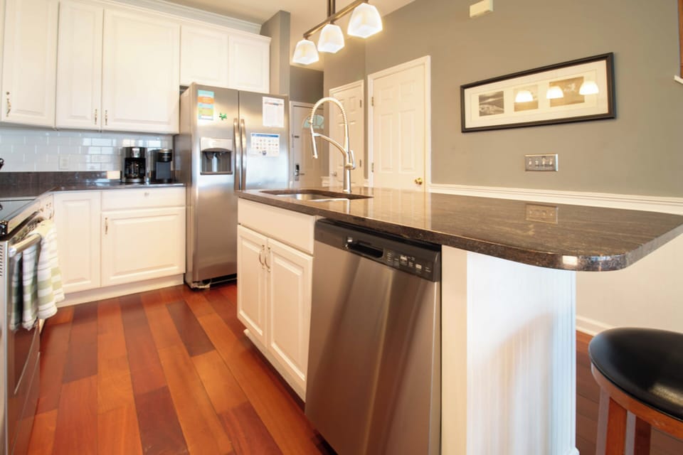 Your fully equipped kitchen features sleek granite countertops, stainless steel appliances, and warm hardwood floors for effortless meal preparation during your stay.