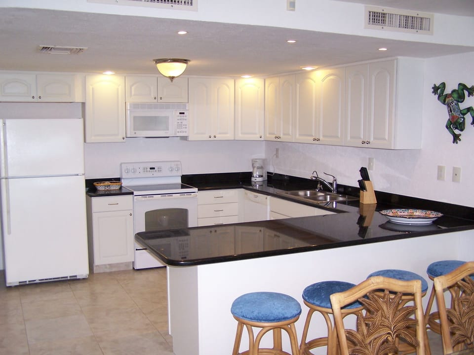Lots of granite countertop with bar & stools.  Ready to prepare a gourmet meal.