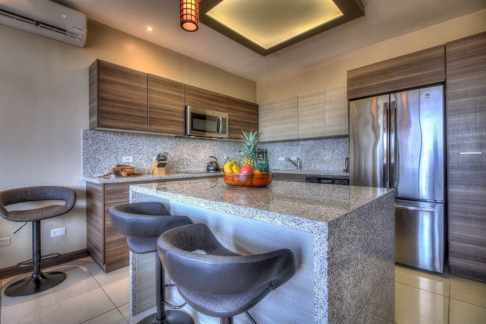 - Spacious kitchen with island seating and pendant lighting   - Stainless steel appliances and granite finishes throughout   - Ideal for cooking tropical meals and entertaining guests