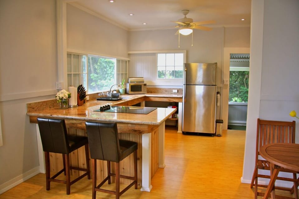 Open upstairs kitchen with bar seating featuring both garden and ocean views!