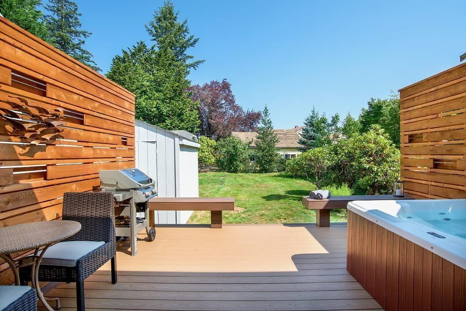 Deck in back with private fenced in back yard, BBQ, seating, and hot tub