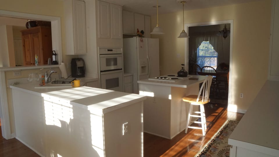 Coffee maker and appliances in kitchen with counter bar for conversation.