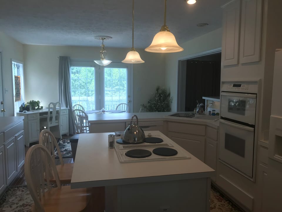 Kitchen view to breakfast room and walkout to deck with grill.