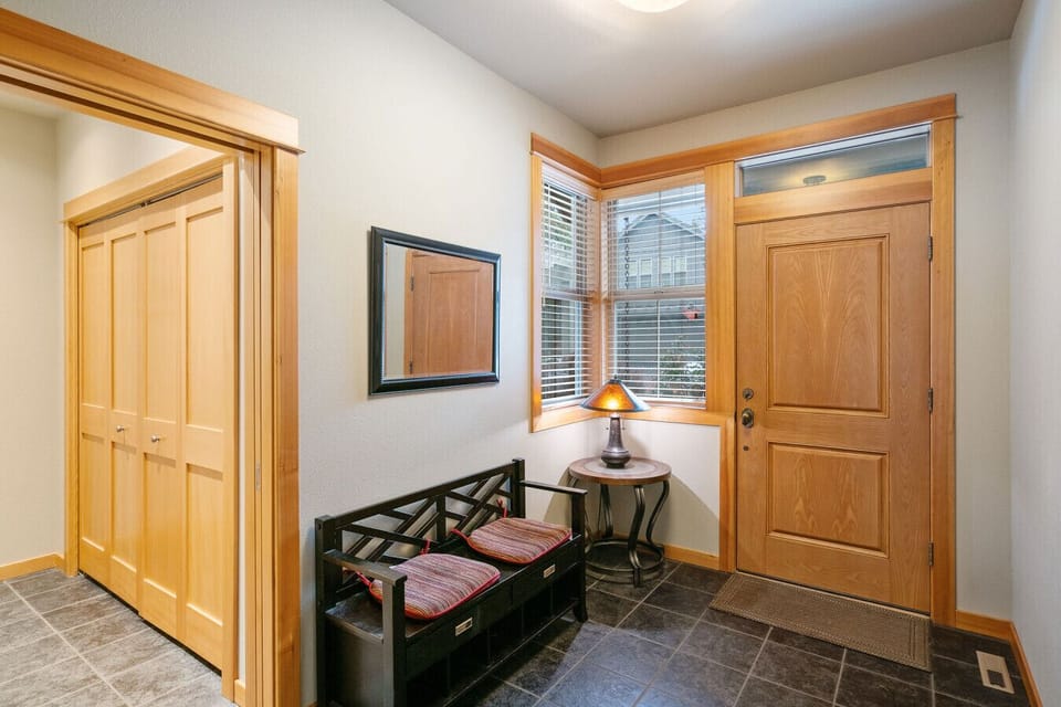 The bright and inviting entryway features a comfortable bench, ample storage, and charming wood accents, setting the tone for a relaxing and well-appointed stay.