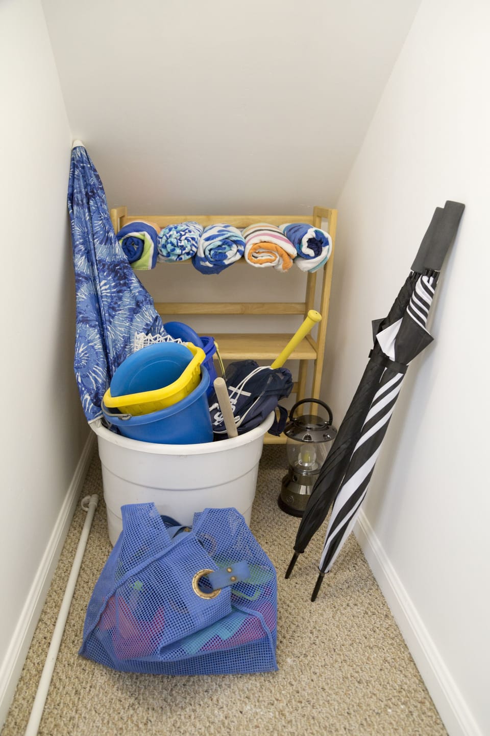 Closet with beach towels and sand toys