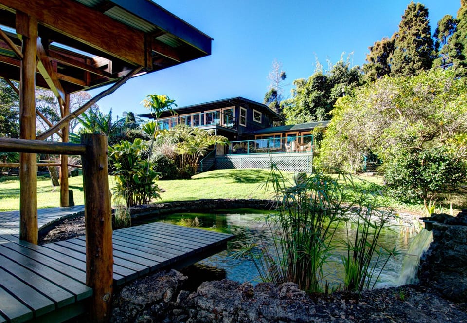 beautiful back of home with lots of decks and koi pond.