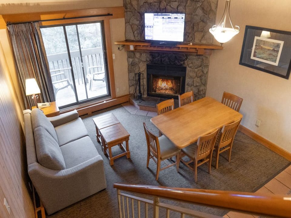Enjoy the comfort of this inviting living and dining area, featuring a rustic charm and cozy furnishings ideal for shared moments.