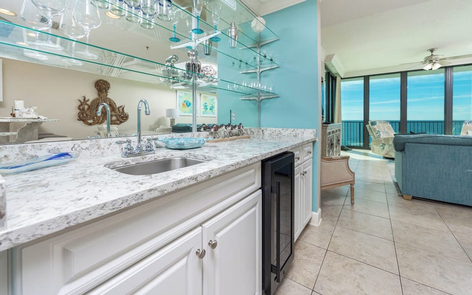 Prepare drinks at the sleek wet bar area, with stylish glassware, wine cooler, and a view that invites socializing